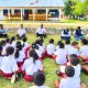 Duduk di Tanah, Dr. Oktelin Beri Semangat Anak-anak SDK Hanono Boas, Serahkan 30 Meja dan 30 Kursi